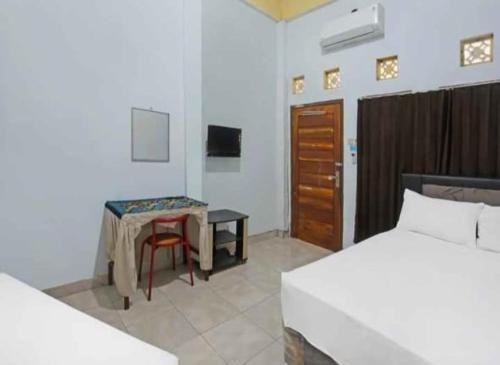 普拉亚Wisma Dhana Syariah的一间卧室配有一张床、一张桌子和一张书桌