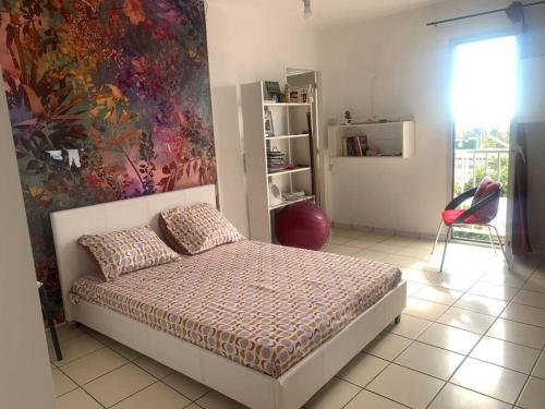 圣克罗蒂德Appartement spacieux的卧室配有一张床,墙上挂有绘画作品