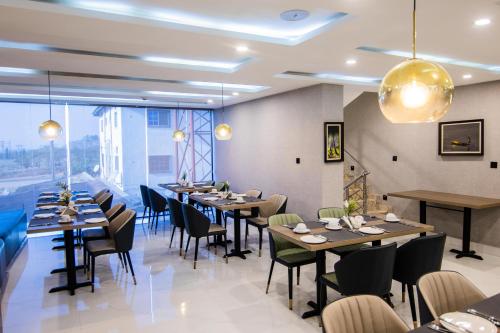 阿布贾BON Hotel Nest Garki II Abuja的餐厅设有桌椅和大窗户。