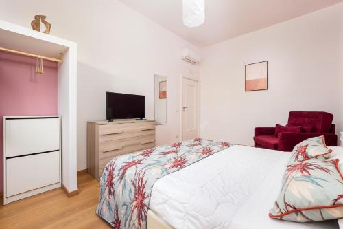 索伦托Smart Home Sorrento - City center的一间卧室配有一张床、一台电视和一把椅子