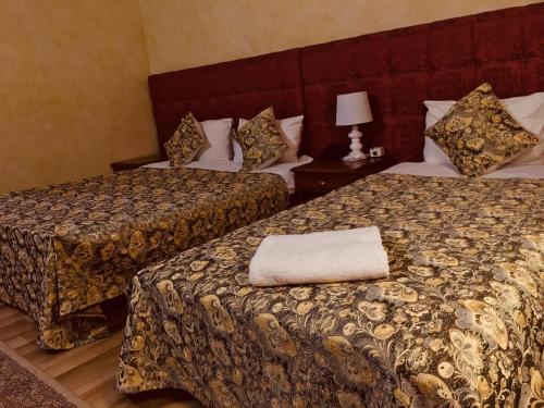 普里什蒂纳HOTEL ORA的酒店客房,设有两张床和一盏灯