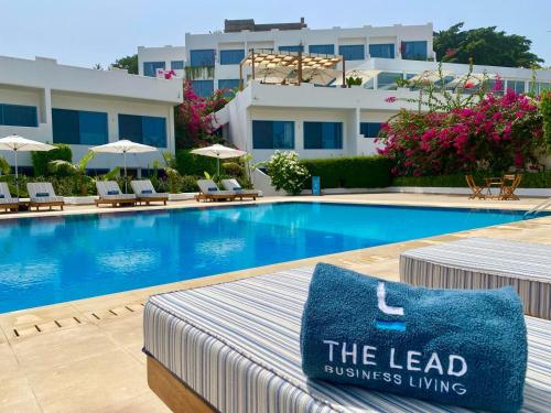 弗里敦The Lead Hotel的酒店的游泳池在床上配有蓝色枕头
