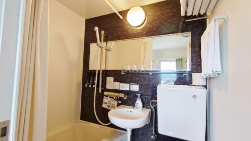 中富良野町拉库琳娜膳食公寓&餐厅的一间带水槽和镜子的小浴室