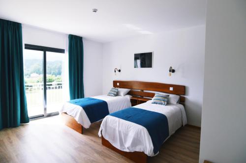 科尔武河畔米兰达Bed & Breakast EQUITARE RURAL的带大窗户的客房内的两张床