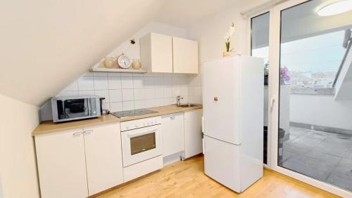 维也纳Fmily Apartment in Praterstern area DW18的厨房配有白色橱柜和白色冰箱。