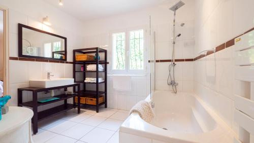 圣特罗佩Camping la Croix du Sud的白色的浴室设有浴缸和水槽。