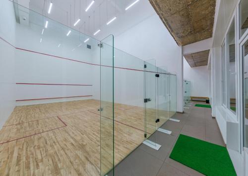 戈尔哈布尔Highland Club Kolhapur的一个带网球场的房间的玻璃隔板
