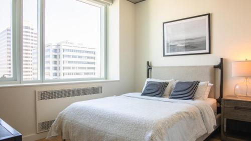 奥克兰Landing Modern Apartment with Amazing Amenities (ID2480X10)的一间卧室配有带2个枕头的床和2个窗户。