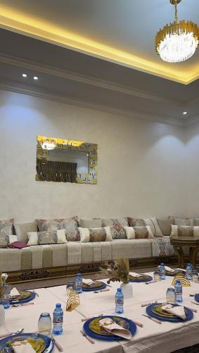 努瓦克肖特MN’s villa的客厅配有沙发和带盘子的桌子