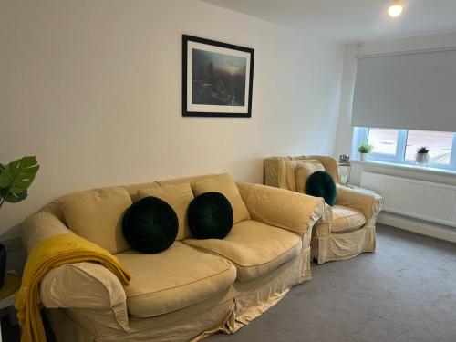 卡迪夫Village House Cardiff - Close to A48 and M4的客厅配有沙发和两个枕头