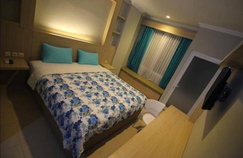 泗水D’Coz Surya Living Pakuwon的一间卧室配有一张带蓝色枕头的床和一扇窗户。