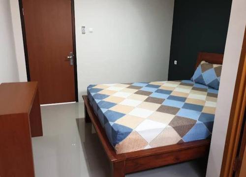 泗水D’Coz Surya Living Pakuwon的一间卧室配有一张带蓝白色床罩的床。