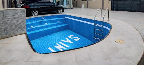 阿克拉Luxury 3 bedroom Villa + Swimming Pool的停车场的游泳池,有车