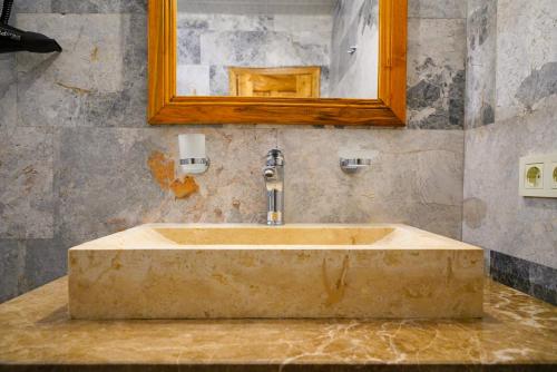 格雷梅萨克斯甘岩洞酒店的浴室设有石质水槽和镜子