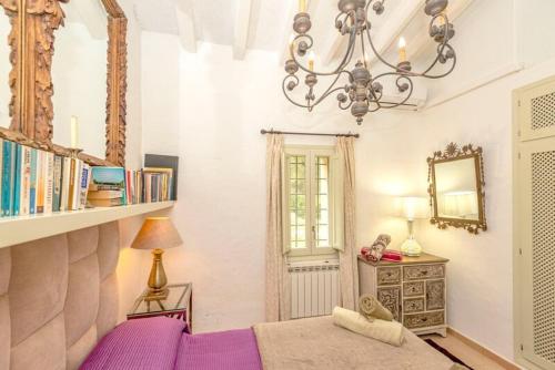 卡拉隆加Can Bet的一间卧室配有紫色的床和吊灯。