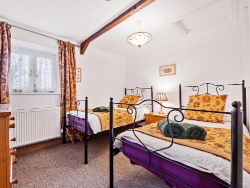 South Barrow达科艾格乡村别墅的卧室设有2张床和白色的墙壁。