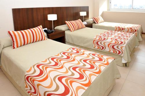 布宜诺斯艾利斯因特苏尔桑特尔摩酒店的一间酒店客房,房间内设有两张床