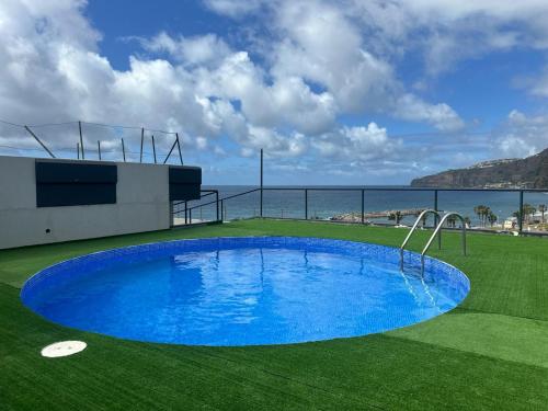 里韦拉布拉瓦Flag Hotel Madeira - Ribeira Brava的绿色的绿色海洋中的蓝色游泳池