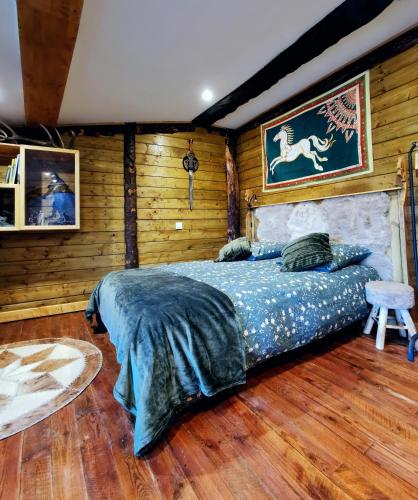 VertaizonSuite privative Le seigneur des Anneaux Arnor的卧室配有一张床铺,位于带木墙的房间内