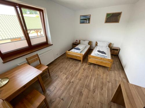 旧松奇Pokoje w Moszczenicy U Pasonia的一间设有两张床和一张桌子的房间
