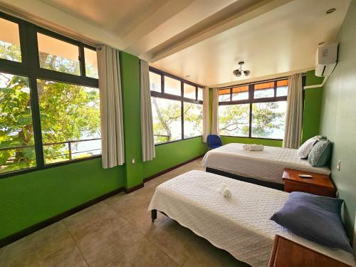 弗洛勒斯Las Luciernagas Hotel Boutique的配有两张床铺的绿色墙壁和窗户
