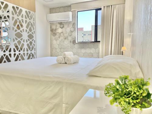 福塔莱萨Aconchego à Beira Mar (no melhor do Meireles)的白色卧室配有一张大床和毛巾