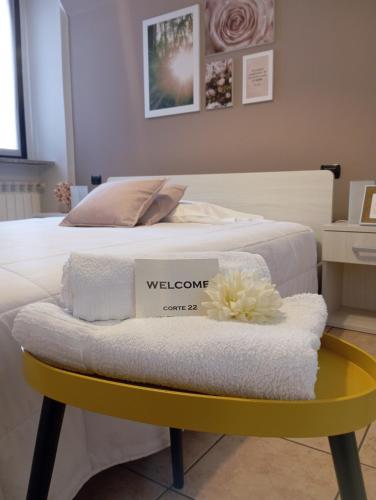 博尔戈马内罗Corte 22 B&b e Appartamenti的一张带黄桌和毛巾的床