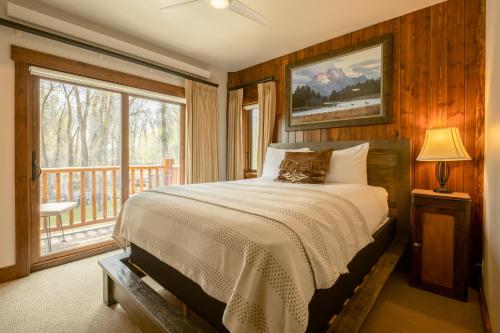 威尔森曲木客栈的一间卧室设有一张床和一个大窗户