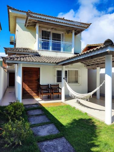 尼泰罗伊Casa Piscina em Condomínio 5min Praia ITACOATIARA.的庭院内带吊床的房子