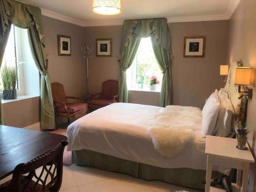 科克Ballea Castle的卧室配有一张白色的大床和一张桌子