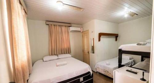 福塔莱萨HOTEL CENTRAL DE FORTALEZA的小房间设有两张床和一张书桌