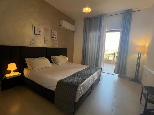 索瓦马Spacious apartments with Sea view at Samarah Resort的一间卧室设有一张床和一个大窗户