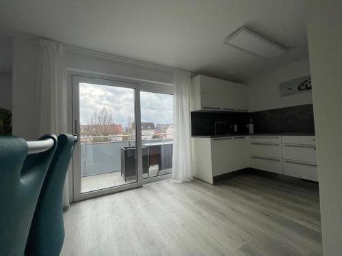 菲尔德施塔特Moderne Apartments in zentraler Lage的厨房设有大型滑动玻璃门和阳台