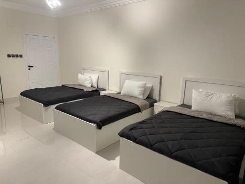 麦地那Almadina Laxury Apartemetns的白色客房的两张床和裙子