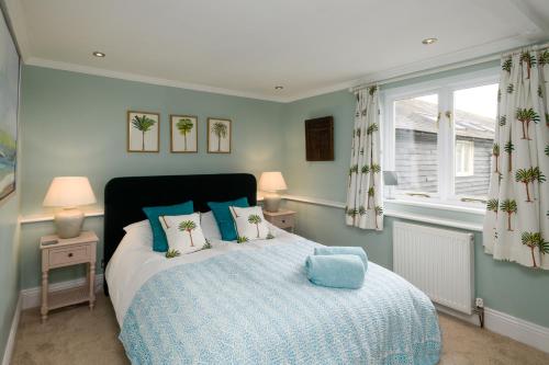 WoodboroughCharming Barn Retreat Near Pewsey & Woodborough的一间卧室配有一张带蓝色枕头的床和一扇窗户。