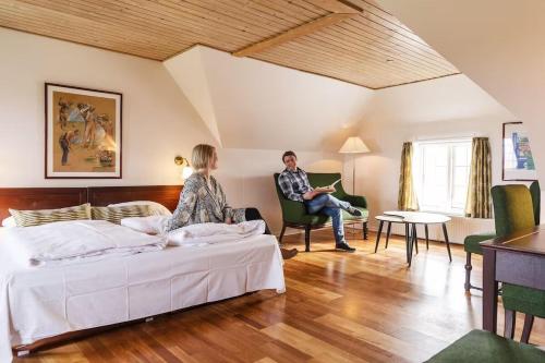 莱姆维HotelVFjorden的坐在卧室椅子上的男人和女人