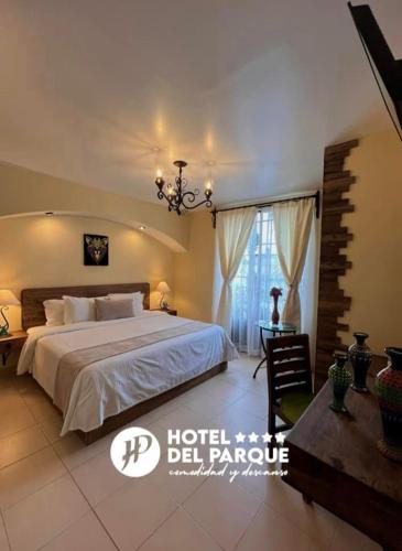 瓦曼特拉Hotel Del Parque的一间卧室配有一张带吊灯的大床