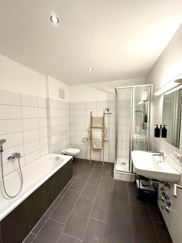 布雷根茨Wohnen deluxe mit Pfänderblick的带浴缸、卫生间和盥洗盆的浴室