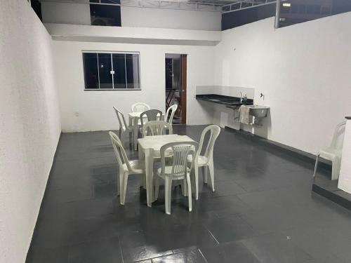 新伊瓜苏Suite 3, Casa Amarela, Terceiro Andar的一间带桌子和白色椅子的用餐室