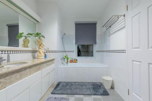 卡里塔LaGita Carita Villa的白色的浴室设有浴缸、水槽和浴缸。