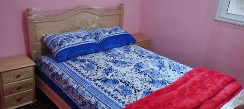 KetamaKetama كتامة的一张带蓝色和白色床单及枕头的床
