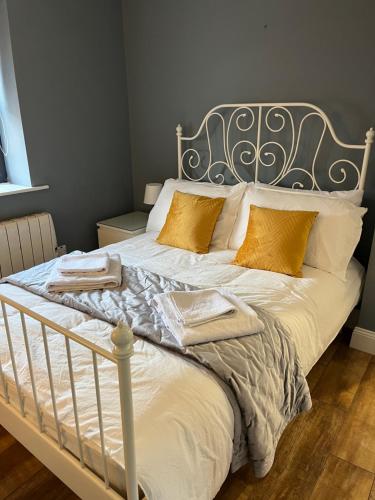 戈尔韦Woodquay Mews的一间卧室配有带白色床单和金色枕头的床。