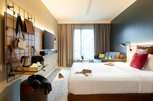 蒙泰夫兰Moxy Paris Val d'Europe的酒店客房设有一张大床和一张沙发。
