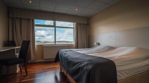 米湖赛尔-米瓦特酒店的一间卧室设有一张床和一个大窗户