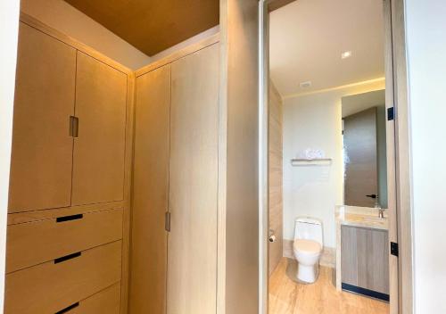 科苏梅尔Brand new condo with Rooftop pool的一间带木制橱柜和卫生间的浴室