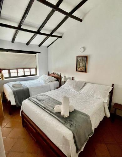 莱瓦镇Hotel-Apartahotel Boutique Piedra & Luna的一间卧室配有两张带毛巾的床