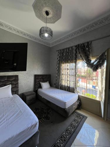 马拉喀什A room in Guéliz only for ladies的一间卧室设有两张单人床和一个窗户。