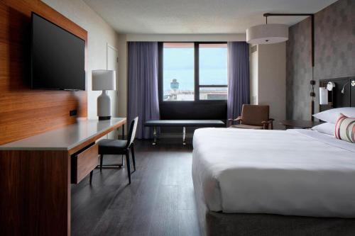 皇后区纽约拉瓜迪亚机场万豪酒店 的酒店客房配有一张床和一张书桌及一台电视