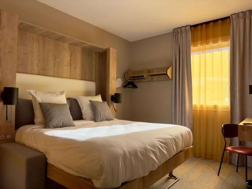 圣让德莫里耶讷Best Western Hotel Coeur de Maurienne的一间卧室设有一张大床和一个窗户。
