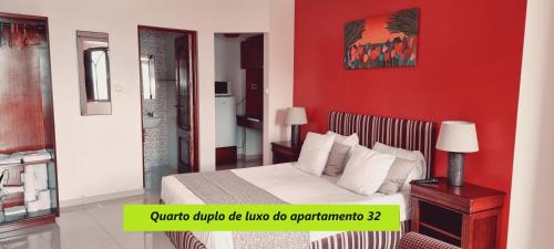 英雄港Príncipe de Mónaco Boutique House的一间卧室配有一张红色墙壁的床